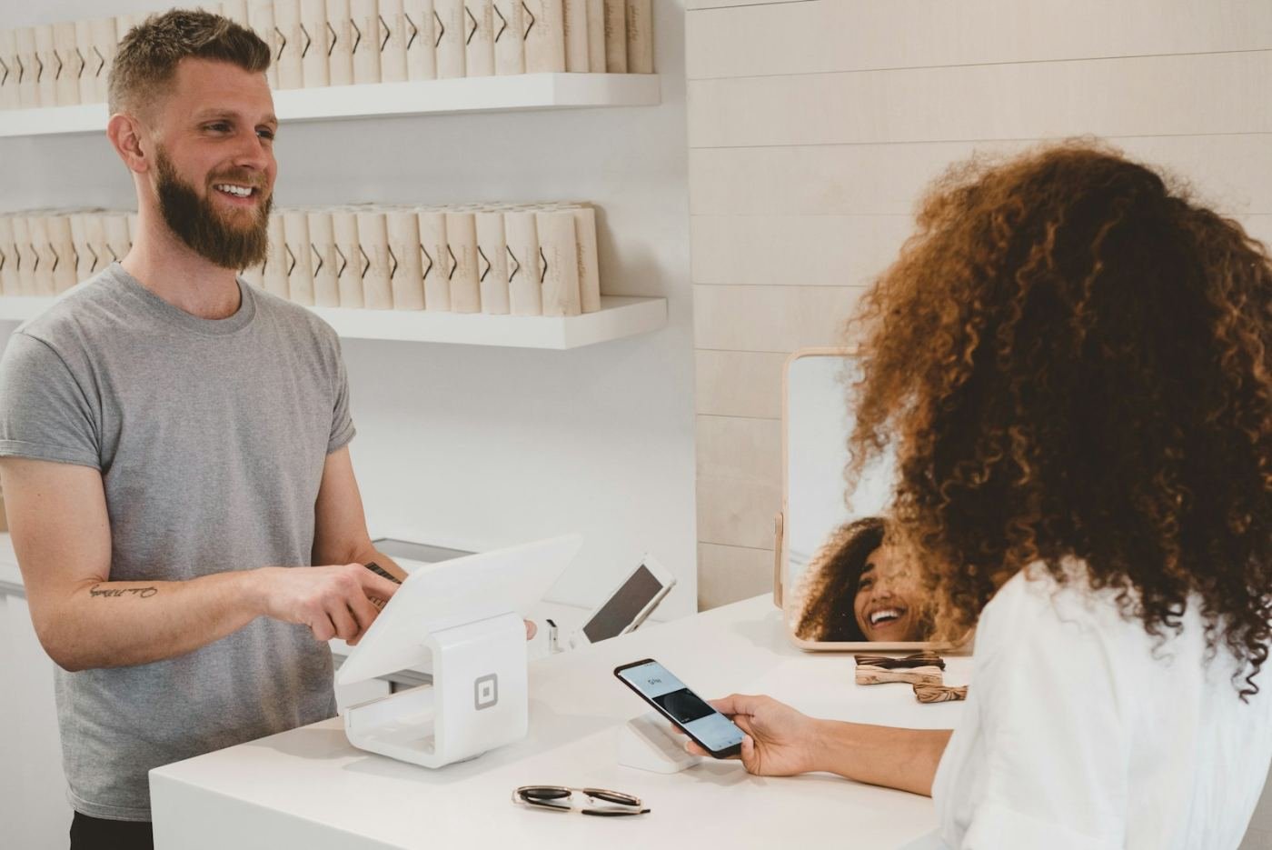 A customer paying by phone at a shop counter.